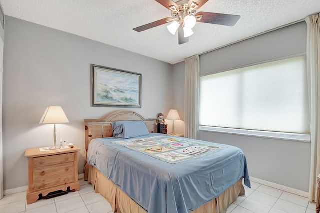 tiled bedroom with ceiling fan and a textured ceiling