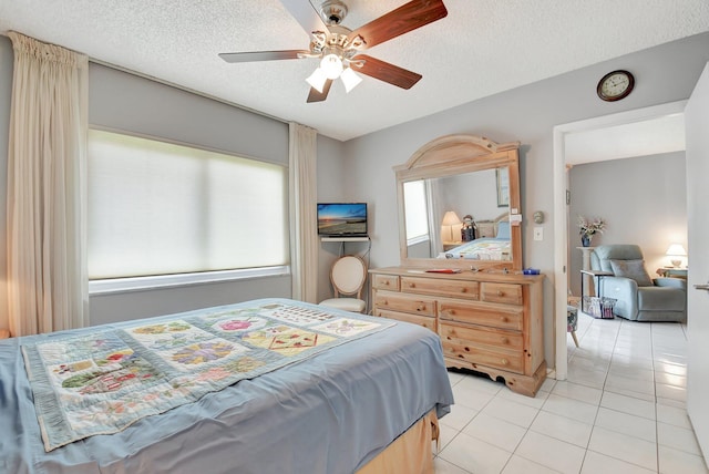 tiled bedroom with ceiling fan and a textured ceiling