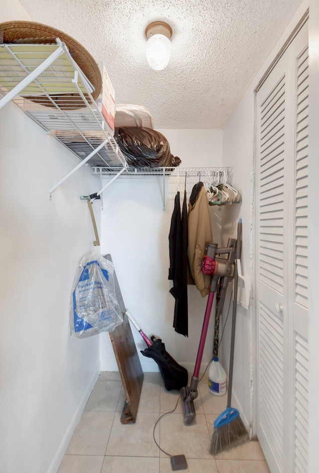 walk in closet with light tile patterned floors