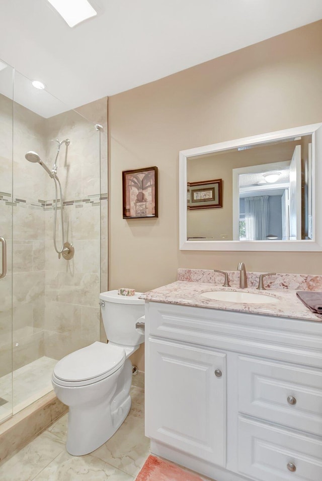 bathroom with vanity, toilet, and a shower with shower door