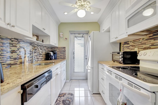 kitchen with sink, white appliances, light tile patterned floors, and white cabinets