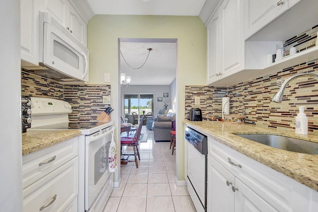 kitchen with sink, white appliances, light tile patterned floors, white cabinetry, and light stone counters