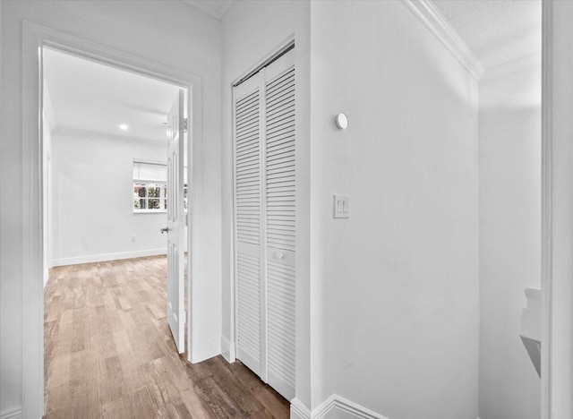 corridor featuring ornamental molding and hardwood / wood-style floors