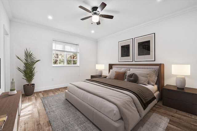 bedroom with crown molding, ceiling fan, and dark hardwood / wood-style floors