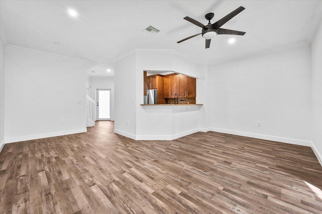 unfurnished living room featuring crown molding, hardwood / wood-style flooring, and ceiling fan