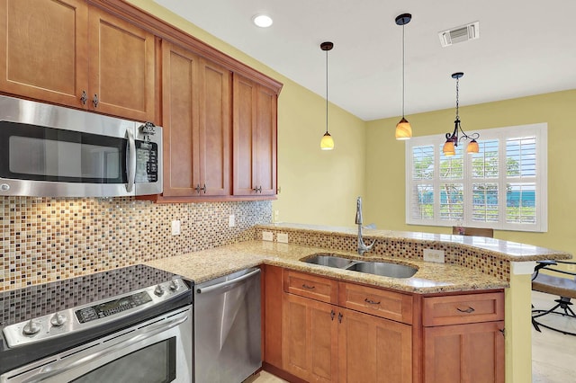 kitchen featuring sink, decorative light fixtures, kitchen peninsula, stainless steel appliances, and backsplash