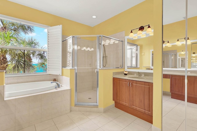 bathroom featuring tile patterned flooring, vanity, and shower with separate bathtub