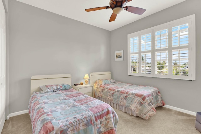 carpeted bedroom featuring multiple windows and ceiling fan