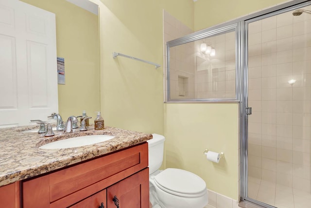 bathroom with a shower with door, vanity, and toilet