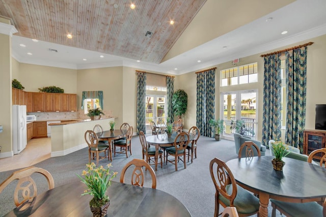 carpeted dining area with ornamental molding, high vaulted ceiling, and wooden ceiling