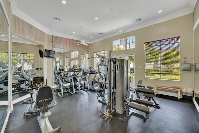 workout area with crown molding, ceiling fan, and a high ceiling