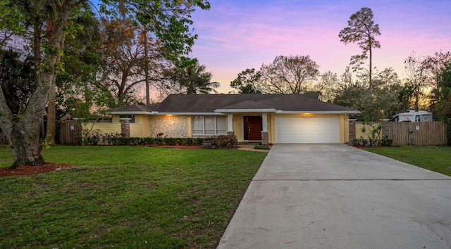 ranch-style home with a yard and a garage