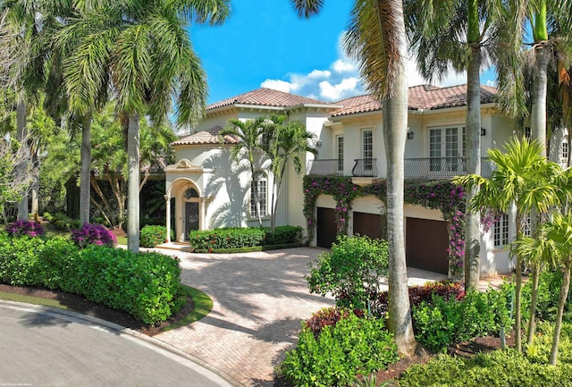 mediterranean / spanish house featuring a garage and a balcony