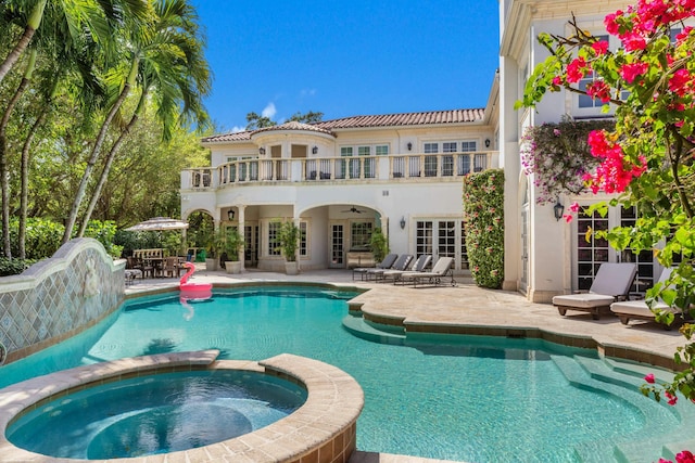 back of property with french doors, ceiling fan, a swimming pool with hot tub, and a patio area