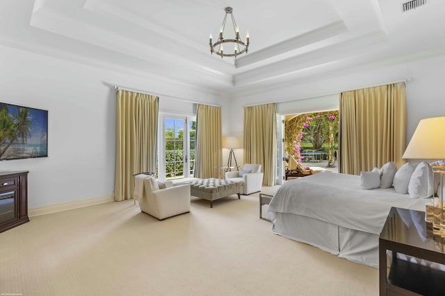 bedroom featuring access to exterior, a tray ceiling, a chandelier, and carpet