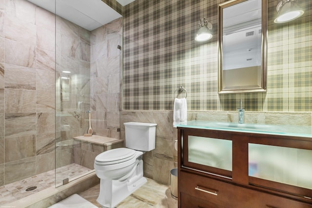 bathroom featuring vanity, toilet, an enclosed shower, and tile walls