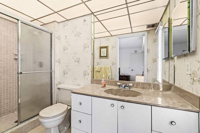 full bathroom with vanity, a shower stall, toilet, and wallpapered walls