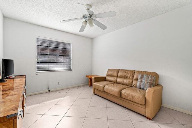 living area featuring light tile patterned floors, a textured ceiling, a ceiling fan, and baseboards