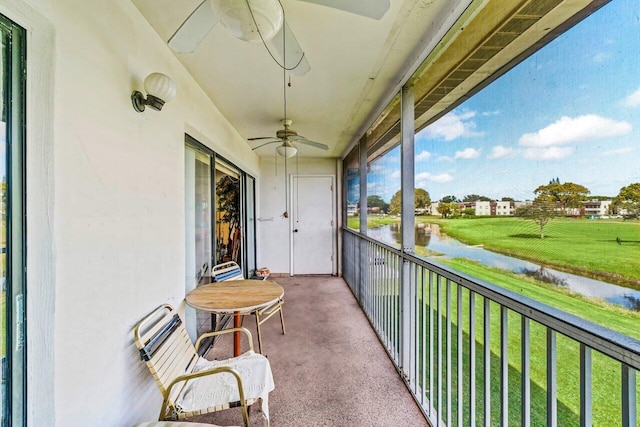 balcony featuring ceiling fan and a water view