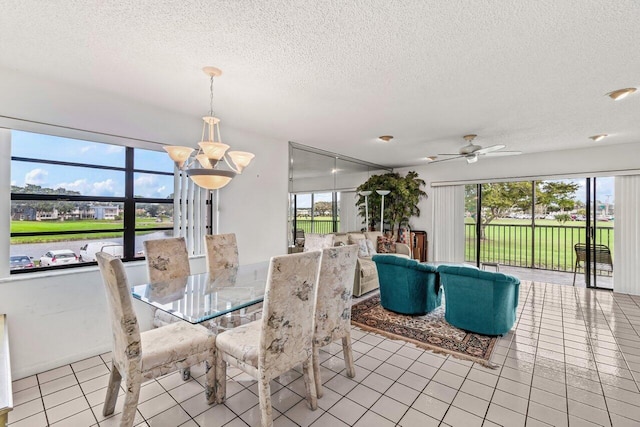 dining room featuring ceiling fan with notable chandelier, a textured ceiling, and tile patterned floors