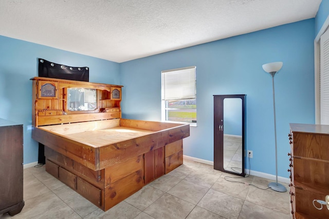 kitchen featuring a textured ceiling and light tile patterned flooring