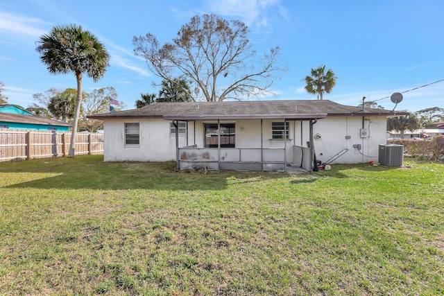 rear view of property featuring a lawn and central air condition unit