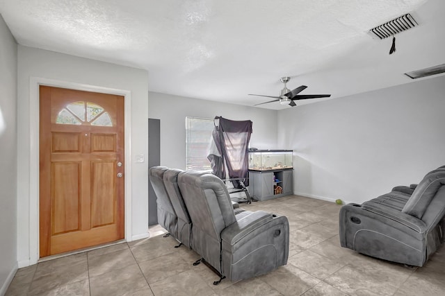 living room featuring a textured ceiling and ceiling fan