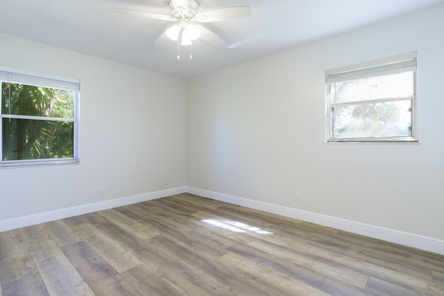 unfurnished room with ceiling fan, light wood-style flooring, and baseboards