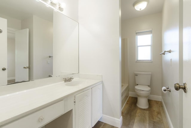 bathroom with vanity, wood-type flooring, and toilet