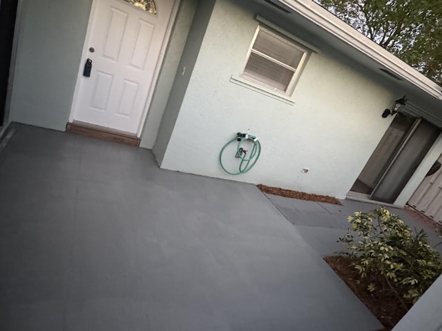 property entrance featuring a patio and stucco siding