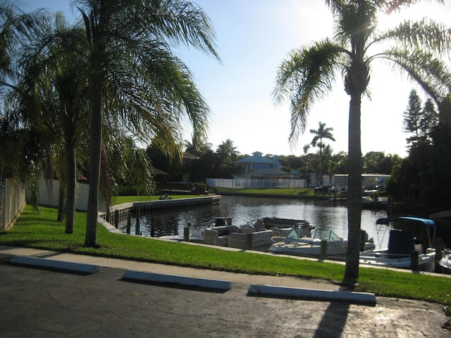 exterior space featuring a lawn, a water view, and fence