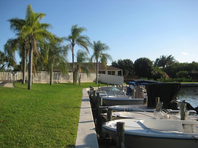 dock area featuring a water view and a yard