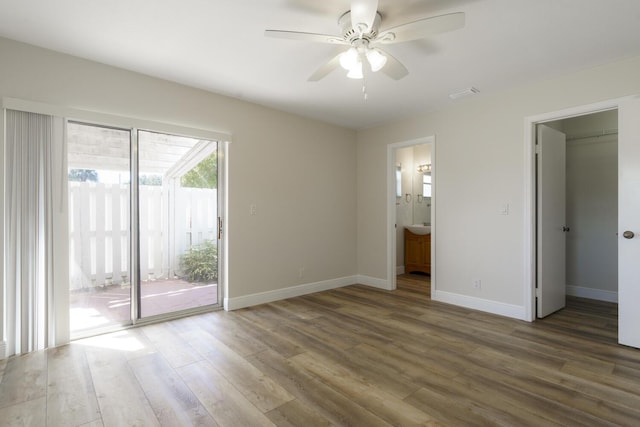 unfurnished bedroom featuring access to outside, baseboards, and dark wood-style flooring