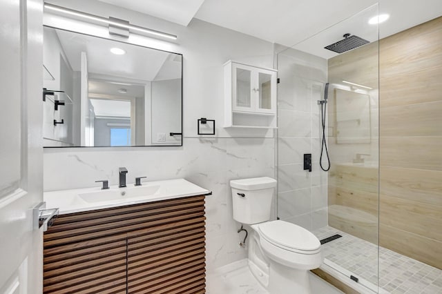 bathroom featuring a tile shower, vanity, tile walls, and toilet