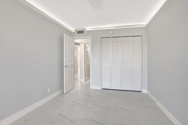 unfurnished bedroom featuring a closet, baseboards, visible vents, and marble finish floor