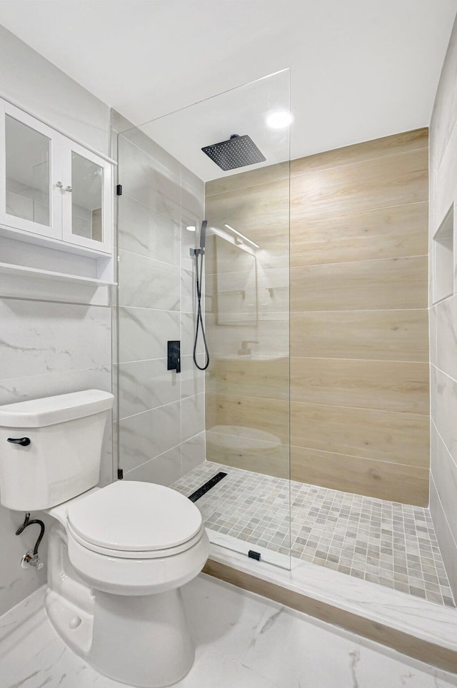 bathroom featuring tiled shower and toilet