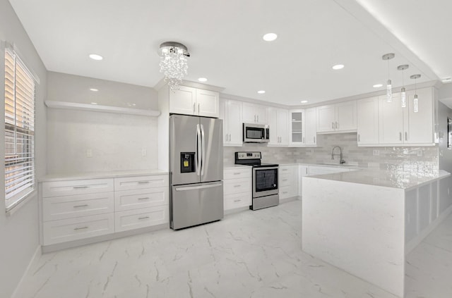 kitchen featuring white cabinetry, glass insert cabinets, a peninsula, marble finish floor, and stainless steel appliances