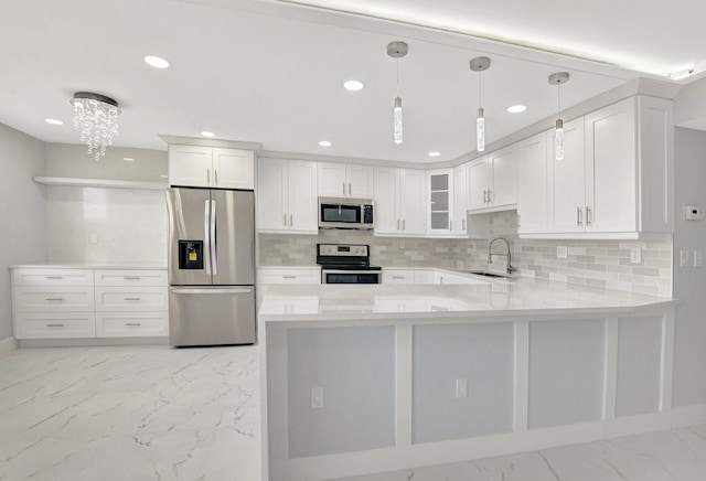 kitchen with pendant lighting, sink, white cabinetry, stainless steel appliances, and tasteful backsplash