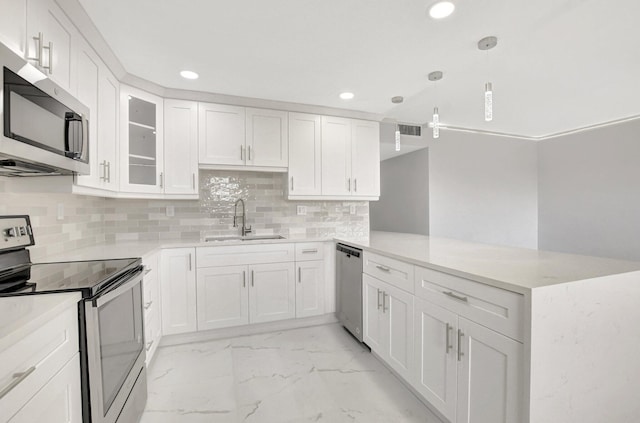 kitchen with sink, white cabinetry, decorative light fixtures, appliances with stainless steel finishes, and kitchen peninsula