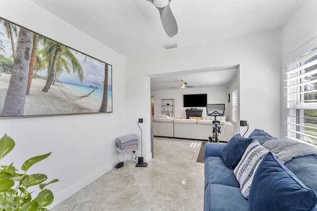 living room with baseboards, plenty of natural light, visible vents, and a ceiling fan