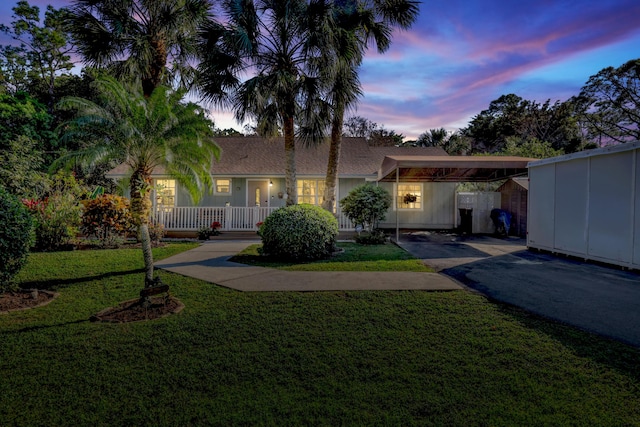 single story home featuring a lawn and a carport