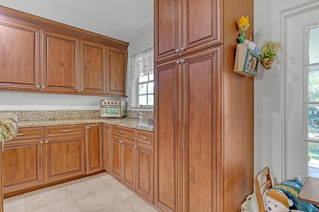 kitchen with light tile patterned flooring and light stone countertops