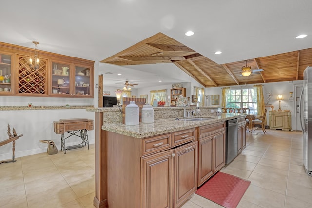 kitchen featuring appliances with stainless steel finishes, pendant lighting, lofted ceiling with beams, sink, and light stone counters