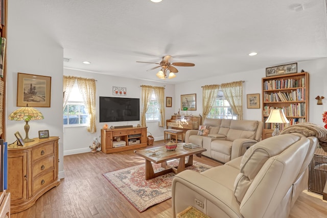 living room featuring light hardwood / wood-style floors and ceiling fan