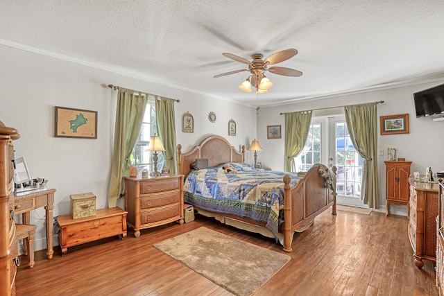 bedroom with multiple windows, access to outside, and light wood-type flooring