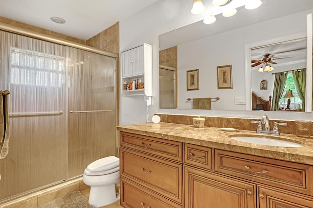 bathroom featuring vanity, ceiling fan, a shower with shower door, and toilet