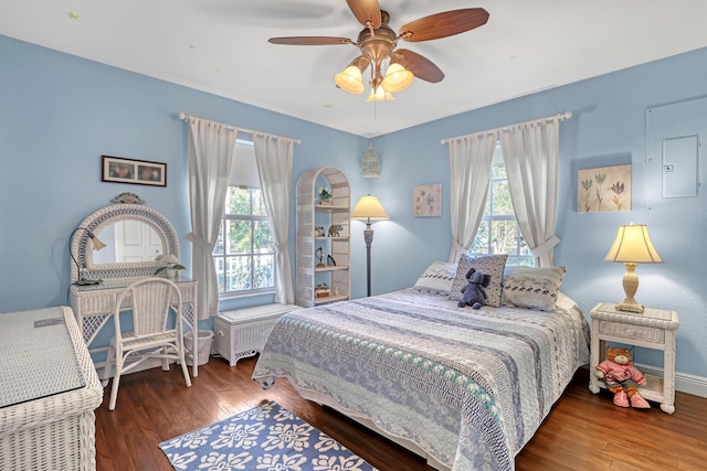 bedroom featuring multiple windows, dark wood-type flooring, and ceiling fan