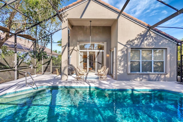 rear view of house with a patio area and glass enclosure