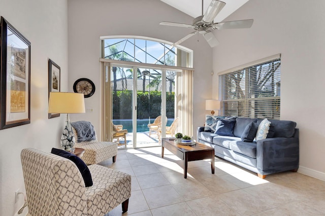 tiled living room with ceiling fan and high vaulted ceiling