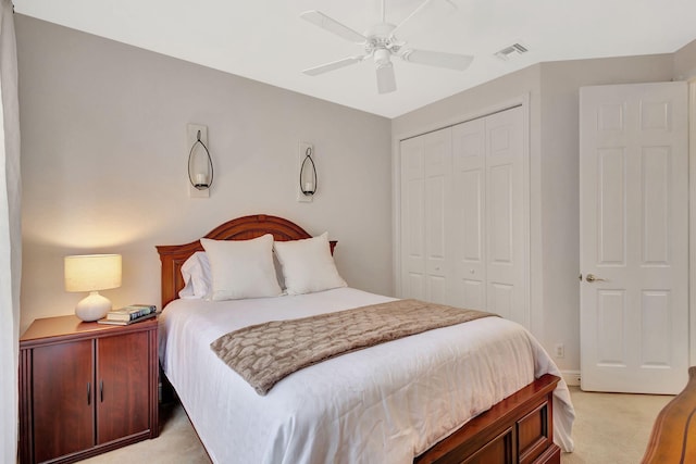 bedroom featuring ceiling fan, light colored carpet, and a closet